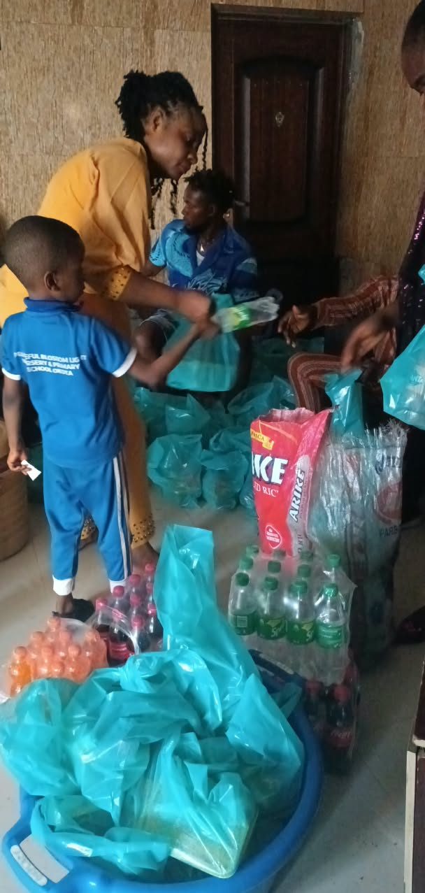 A boy in his primary school uniform collecting a bag of supplies from Ogochukwu Helping Hands Foundation