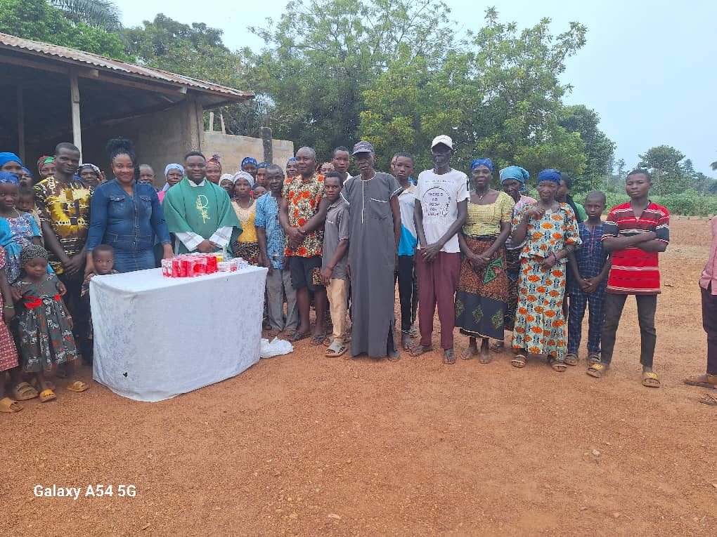 Nurse Vivian Okafor standing with a whole rural community and their parish priest at an outreach